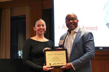 Anthony Barksdale standing with a student holding an award