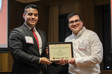 BOSE representative holding an award and standing next to a student