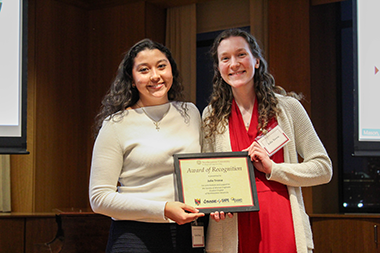 Julia Tresse standing with a student holding an award