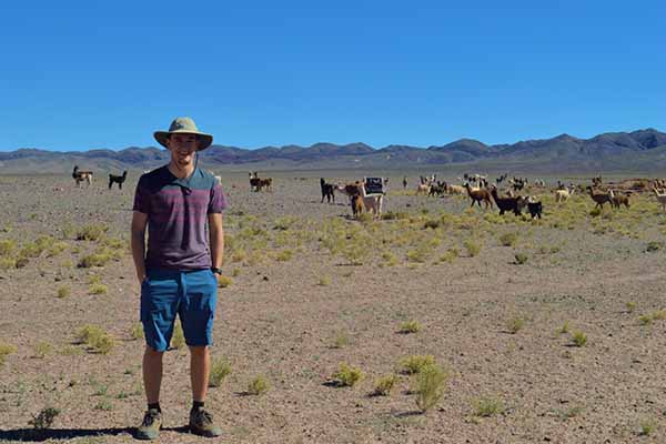 student in chili with desert and cattle in background